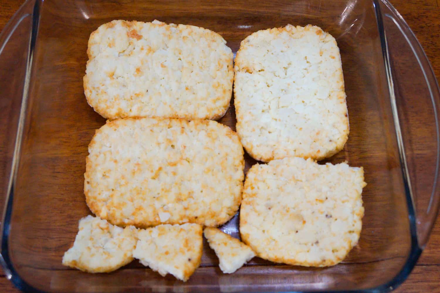 frozen hash brown patties in the bottom of a baking dish