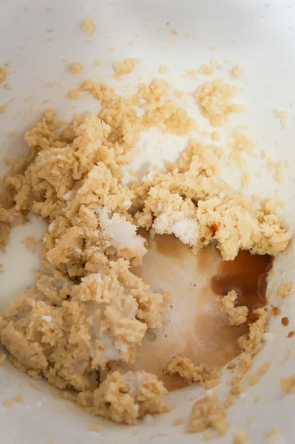 vanilla extract and salt added to cookie dough mixture in a mixing bowl