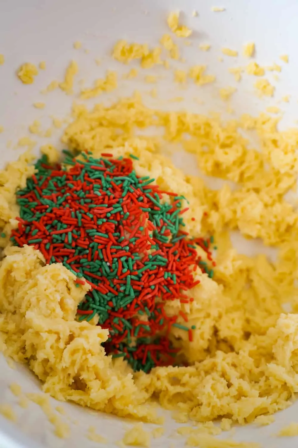 sugar cookie dough with red and green sprinkles in a mixing bowl