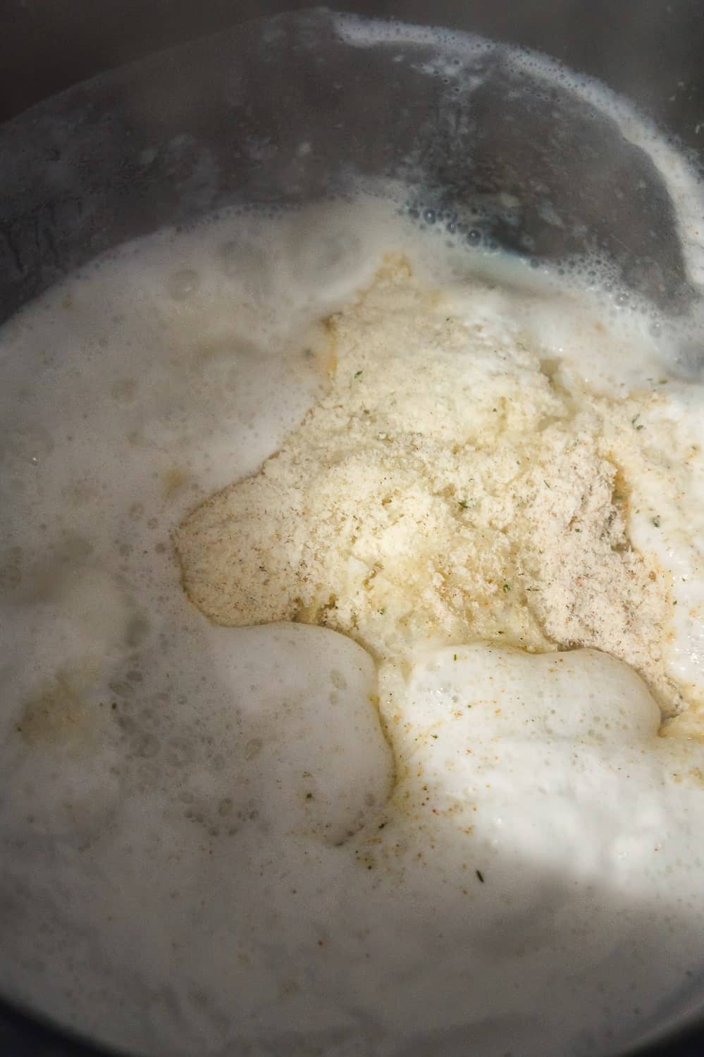 powdered mashed potatoes being added to boiling milk