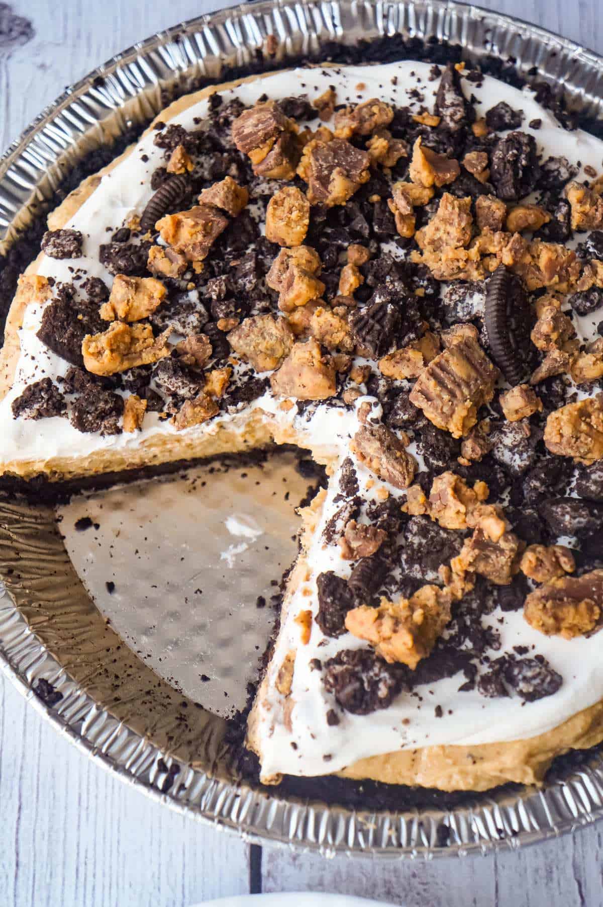 No Bake Oreo Peanut Butter Cup Cheesecake is a quick and easy dessert recipe perfect for any occasion. An Oreo cookie pie crust is filled with a delicious peanut butter and cream cheese mixture loaded with pieces of Reese's Peanut Butter Cups and Oreo cookies. This chocolate peanut butter dessert is perfect for summer.