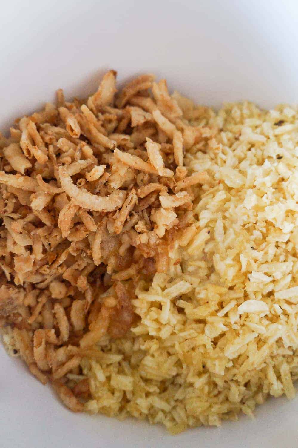 crushed potato chips and French's fried onions in a mixing bowl