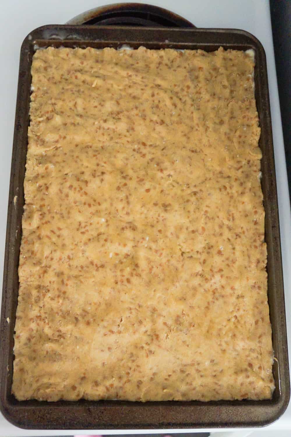 pumpkin spice sugar cookie dough pressed out on baking sheet