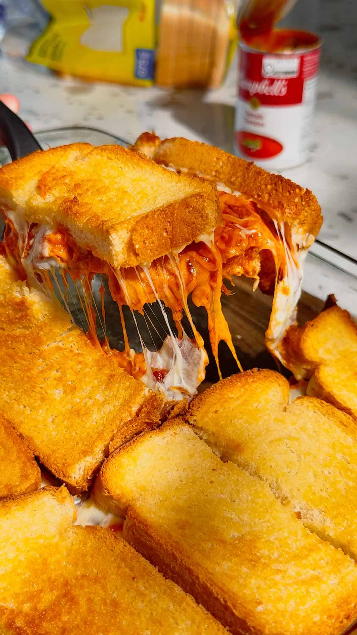scooping tomato soup and bacon grilled cheese casserole