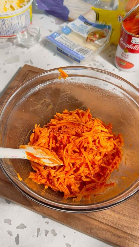shredded cheese and tomato soup mixture in a mixing bowl