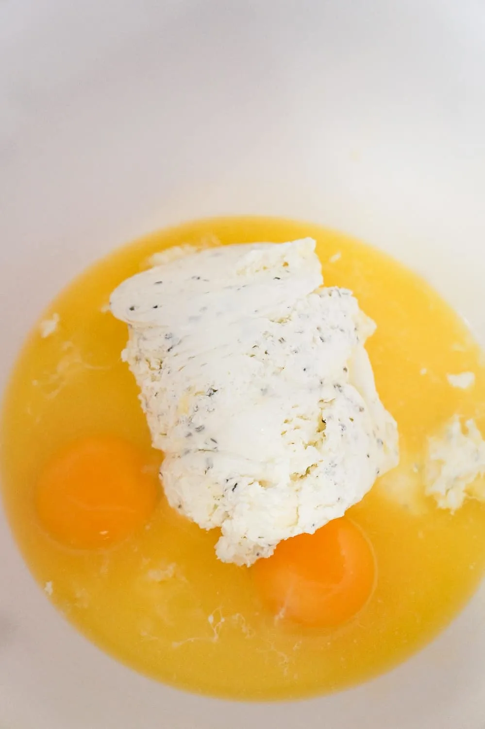 Philadelphia whipped cream cheese in a bowl with eggs and melted butter