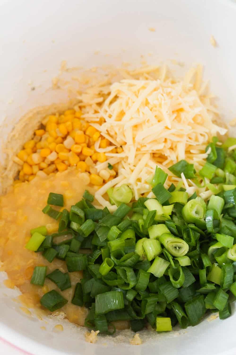 corn, cream corn, chopped green onions and shredded Harvati in a baking dish.