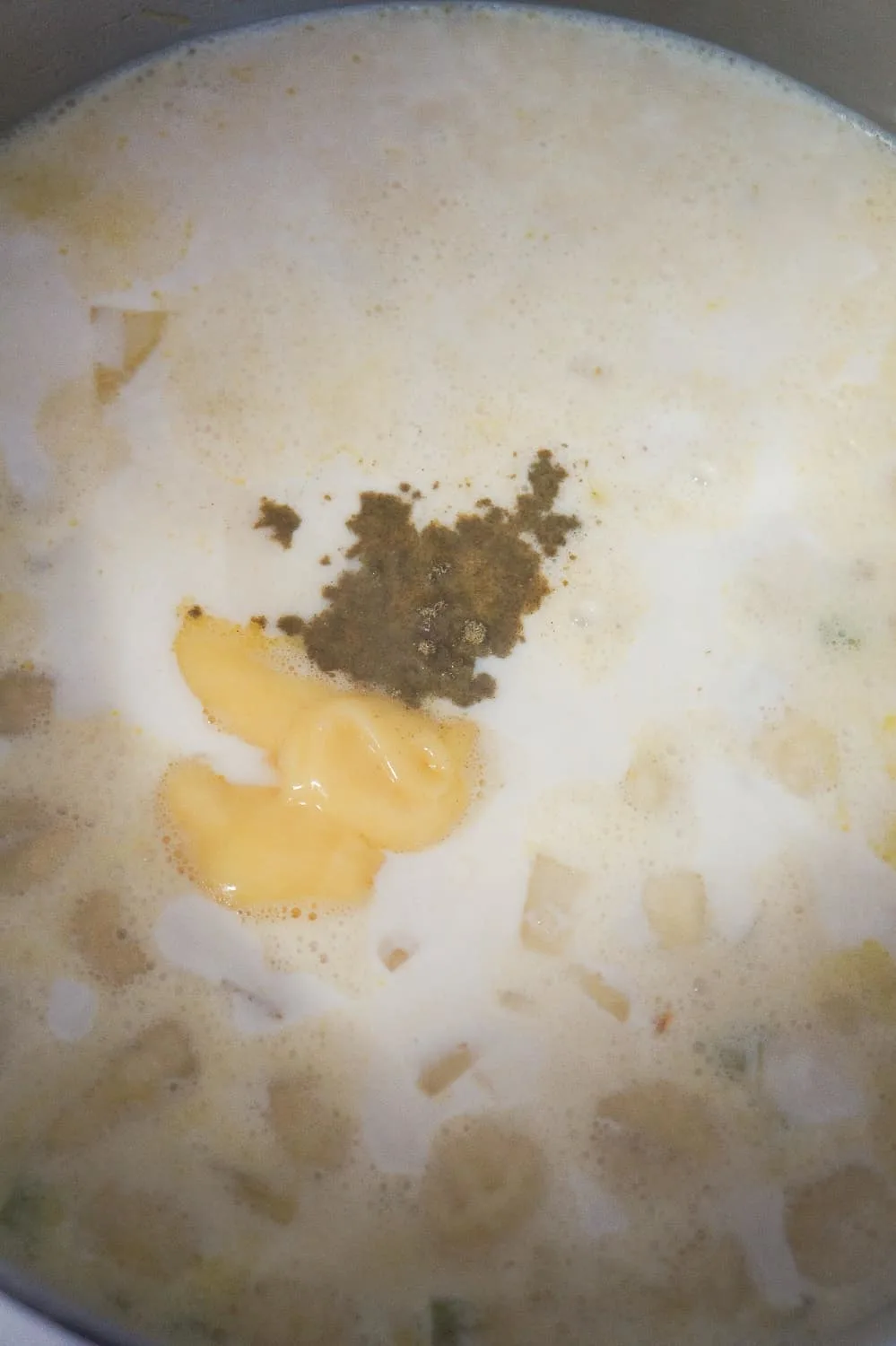 cream of chicken soup, sage and pepper being added to creamy gnocchi soup