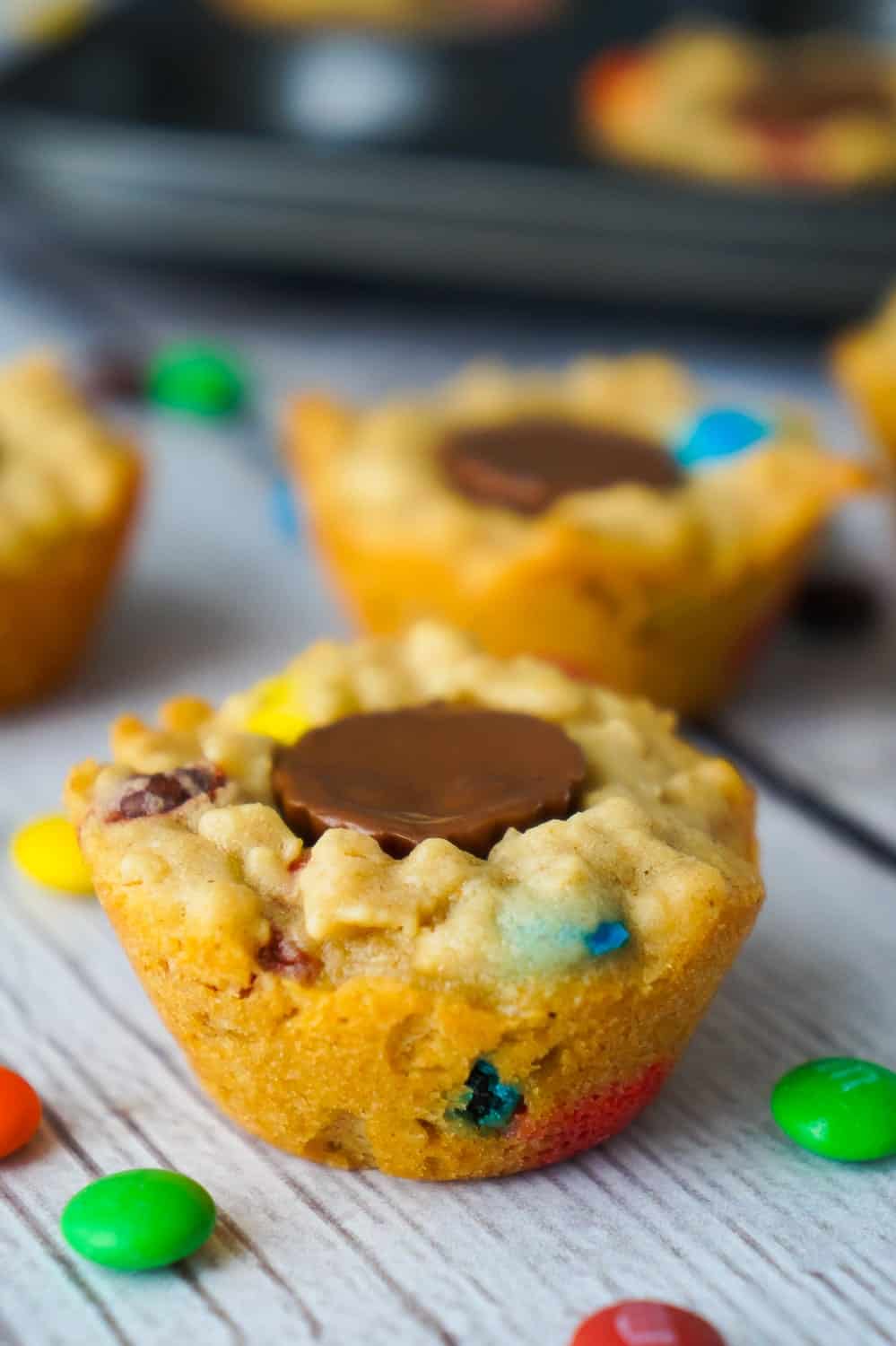 These Peanut Butter Cup Stuffed Monster Cookie Cups are a fun and easy dessert recipes. The oatmeal peanut butter cookies are loaded with mini M&Ms and each cookie cup has one mini Reese's peanut butter cup pressed into the center.