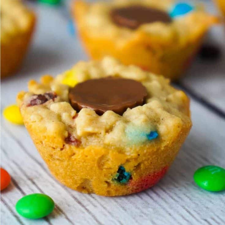 These Peanut Butter Cup Stuffed Monster Cookie Cups are a fun and easy dessert recipes. The oatmeal peanut butter cookies are loaded with mini M&Ms and each cookie cup has one mini Reese's peanut butter cup pressed into the center.