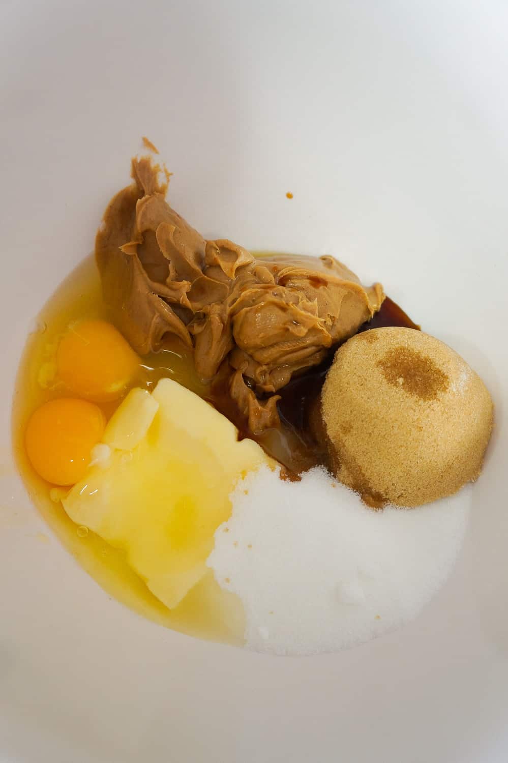 eggs, butter, peanut butter, white sugar and brown sugar in a mixing bowl