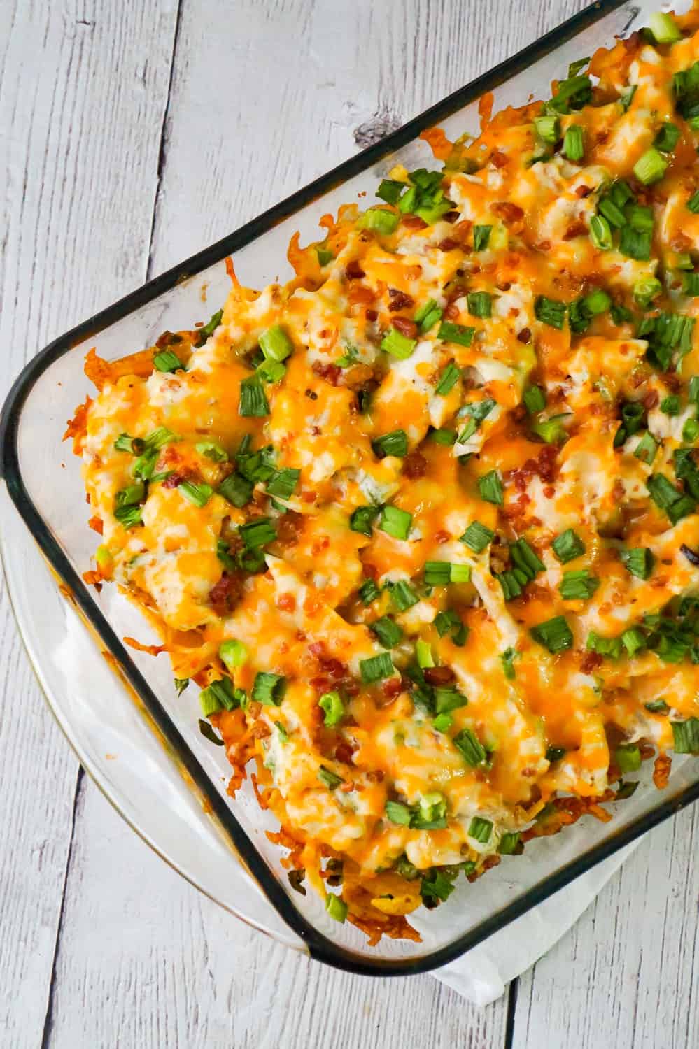 Chicken Bacon Ranch Frito Pie is a quick and easy dinner recipe using rotisserie chicken. This tasty casserole starts out with a base of Frito's corn chips topped with a mixture of shredded chicken, real bacon bits, green onions and ranch dressing, finished off with a layer of shredded cheese.
