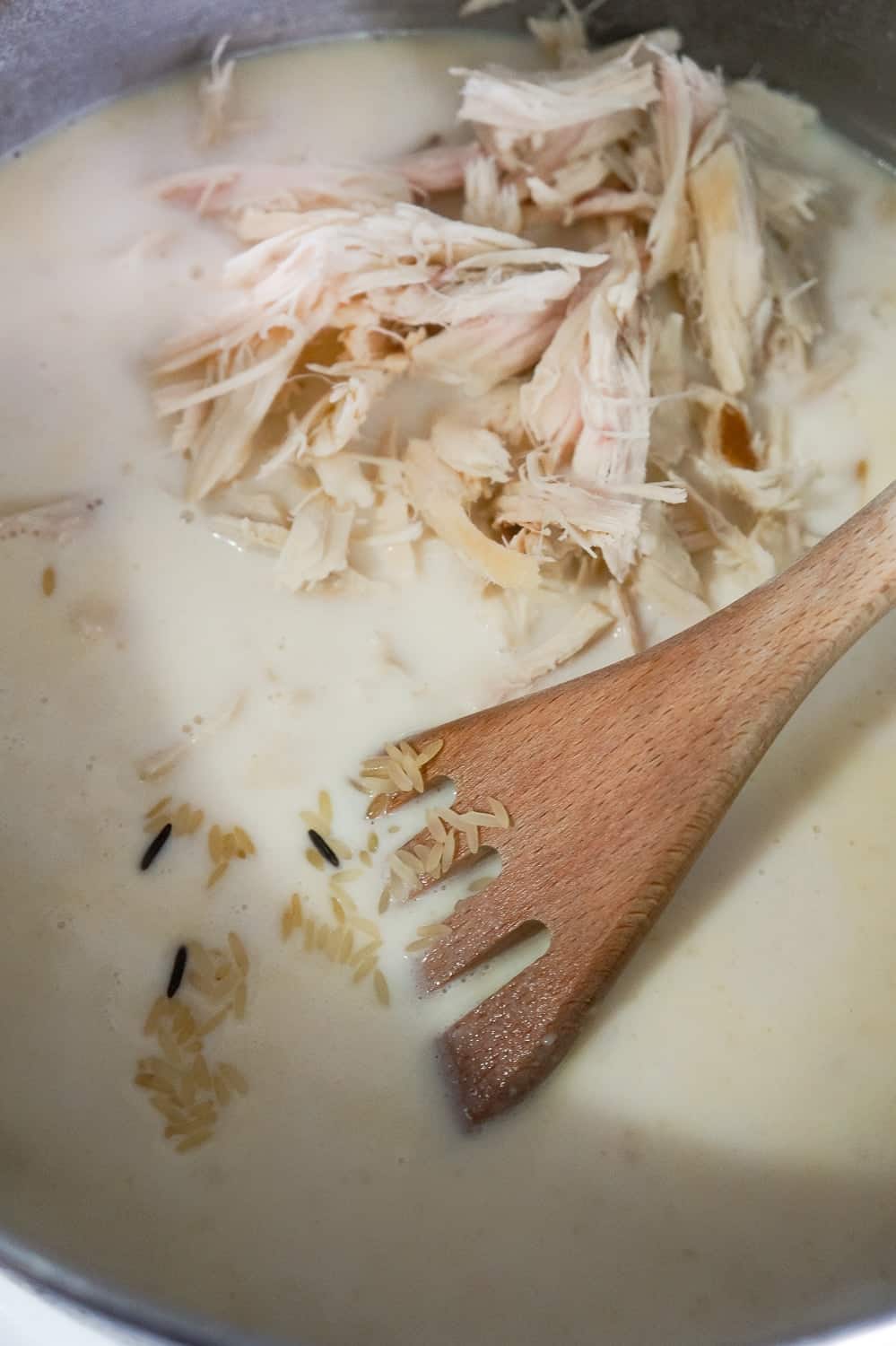 shredded turkey and rice being added to milk and chicken broth mixture
