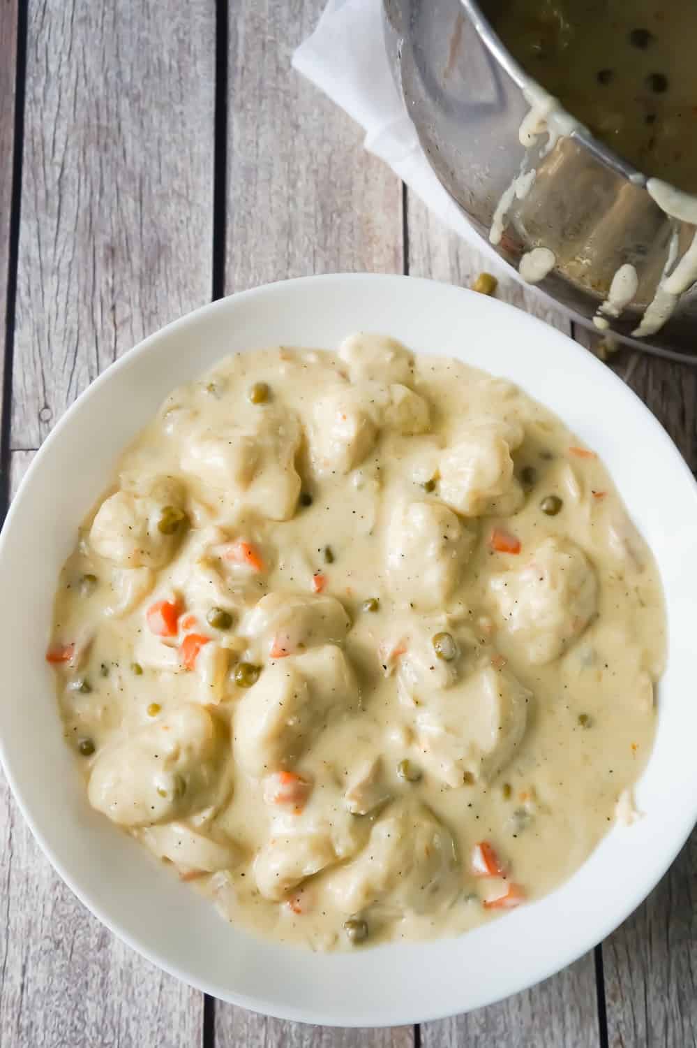 Easy Chicken and Dumplings with Biscuits is a simple weeknight dinner recipe using rotisserie chicken and Pillsbury refrigerated biscuits. These creamy chicken and dumplings are a hearty comfort food dish perfect for cold weather.