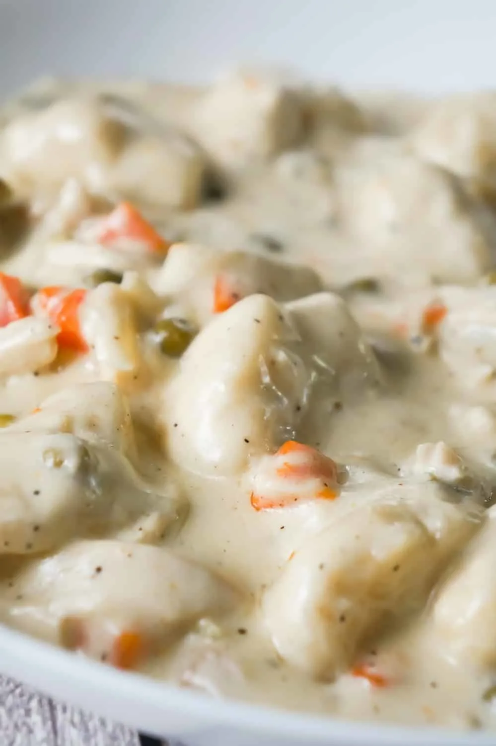 Easy Chicken and Dumplings with Biscuits is a simple weeknight dinner recipe using rotisserie chicken and Pillsbury refrigerated biscuits. These creamy chicken and dumplings are a hearty comfort food dish perfect for cold weather.