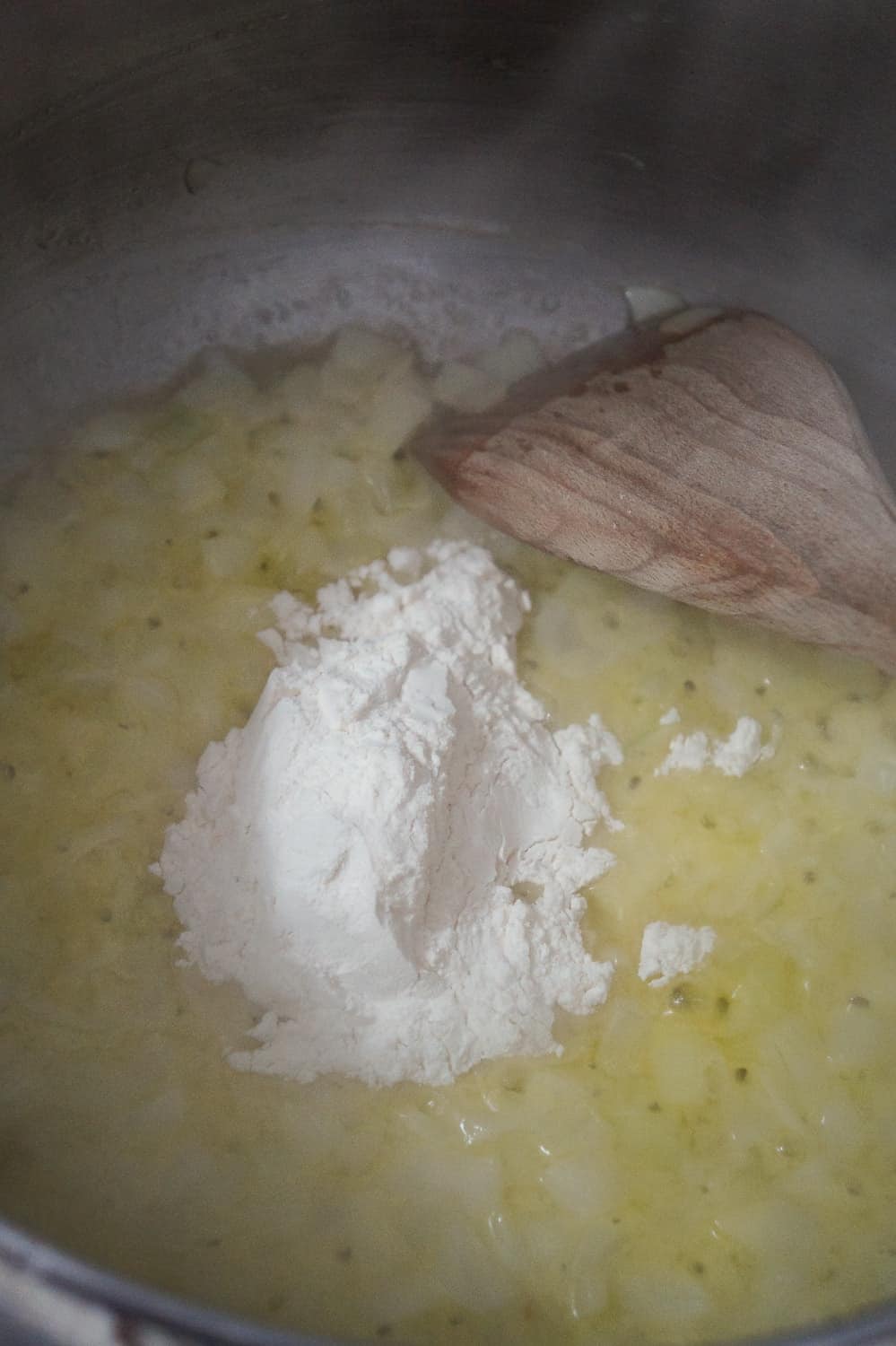 all purpose flour added to a pot with diced onions and butter