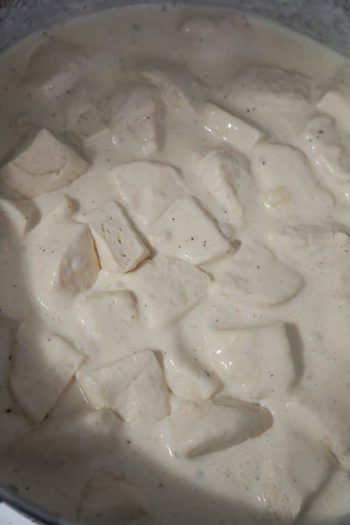 Pillsbury biscuit dough cooking in a creamy sauce