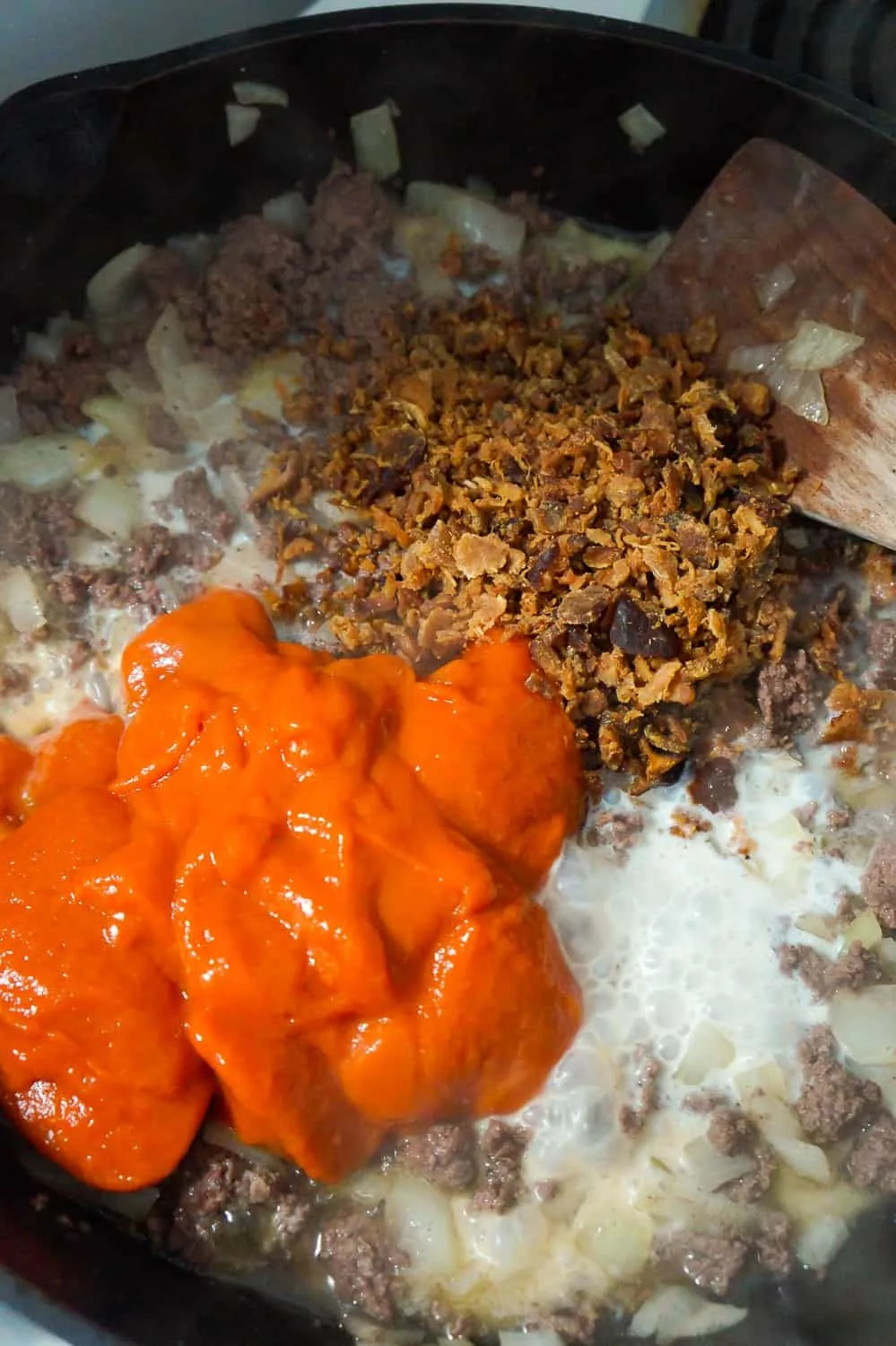 condensed tomato soup, milk and real bacon bits added to cooked ground beef in a frying pan