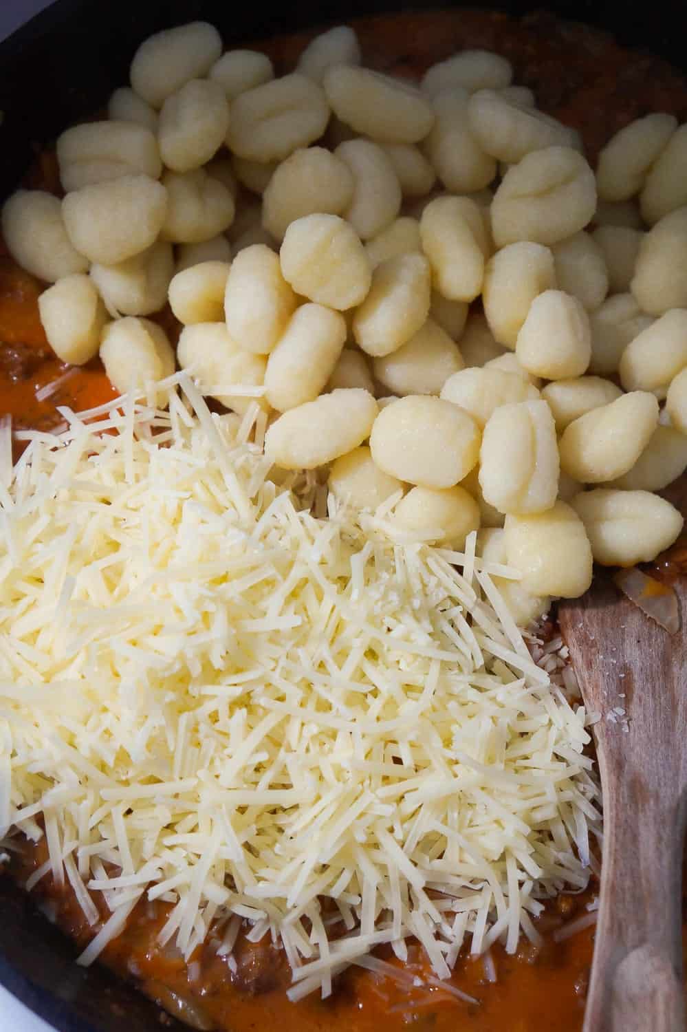 cooked gnocchi and shredded parmesan cheese added to frying pan