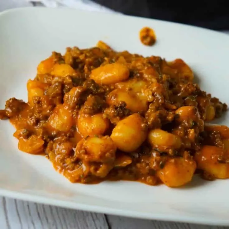 Gnocchi and Ground Beef with Tomato Sauce is an easy weeknight dinner recipe that takes less than 30 minutes from start to finish. These delicious mini potato dumpling are tossed in a sauce made from condensed tomato soup, along with some ground beef and real bacon bits.
