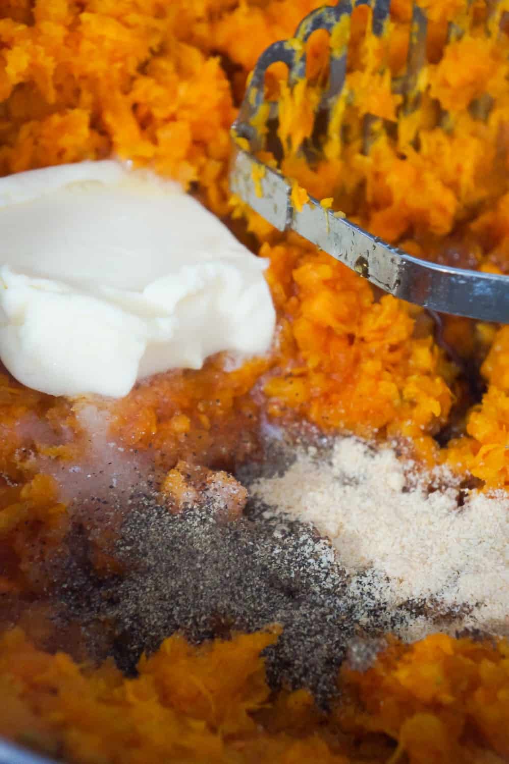 butter, salt, pepper and onion powder on top of mashed sweet potatoes