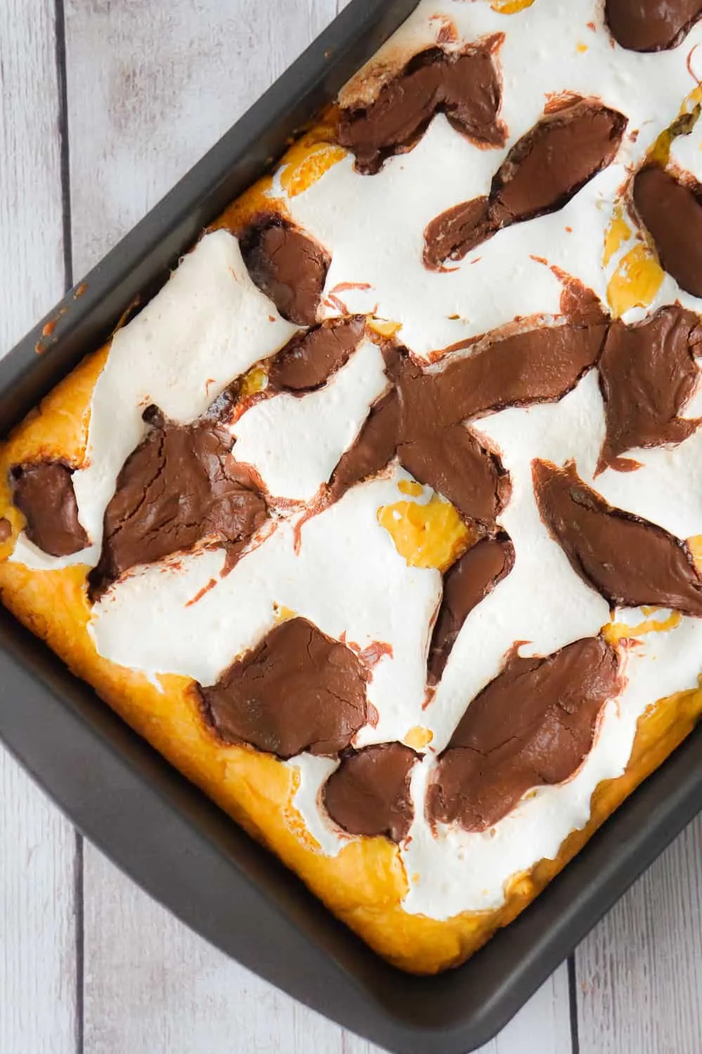 Nutella S'mores Cookie Cake is an easy dessert recipe using boxed cake mix. This delicious chocolate chip cookie cake is loaded with Nutella and Marshmallow Fluff.