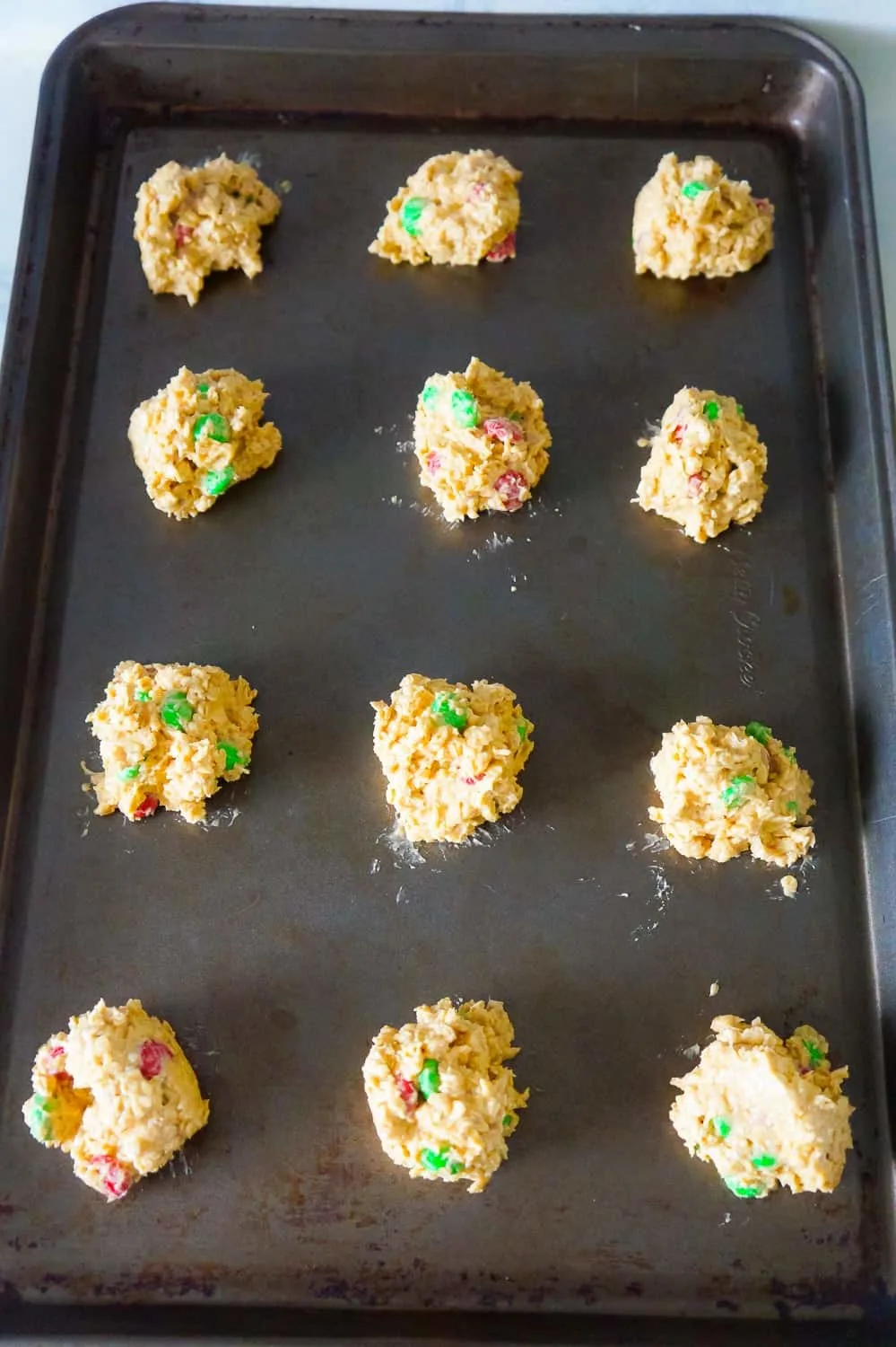 balls of Christmas monster cookie dough on a baking shet