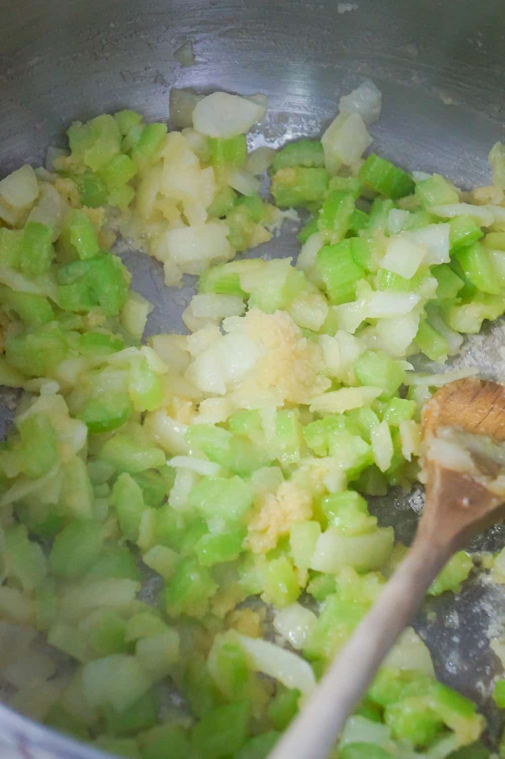 diced onion and diced celery cooking in a pot with flour and butter