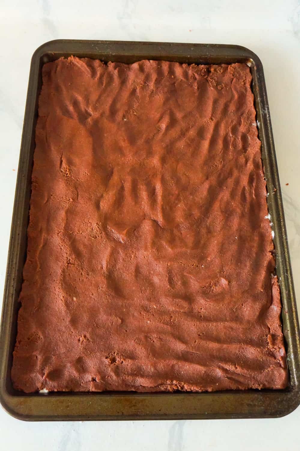 chocolate sugar cookie dough pressed out on baking sheet