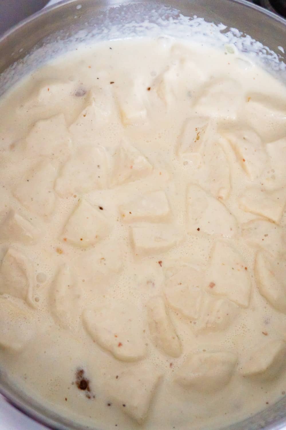 pieces of Pillsbury biscuit dough floating in a creamy liquid