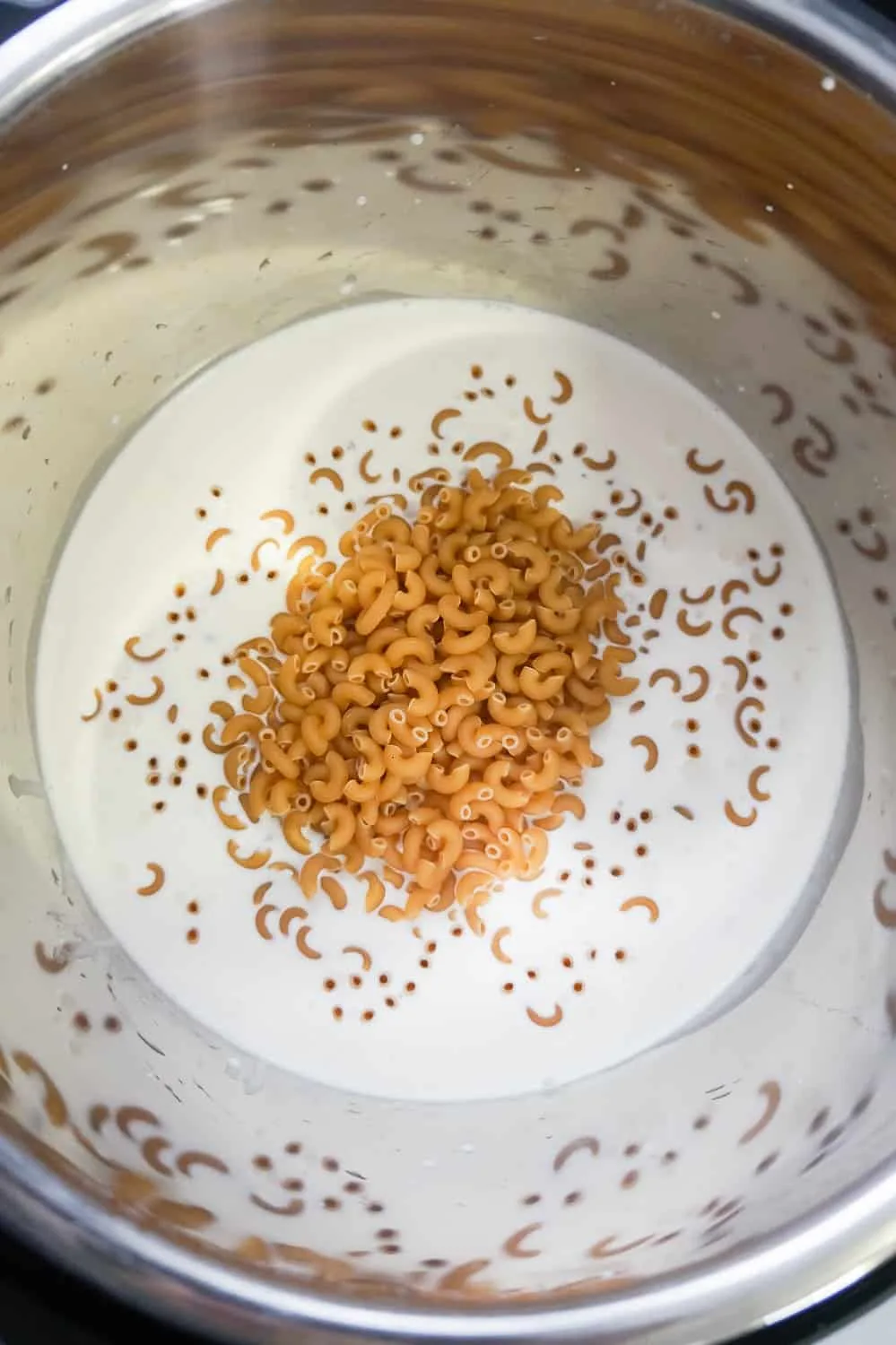 uncooked macaroni noodles and heavy cream in an Instant Pot