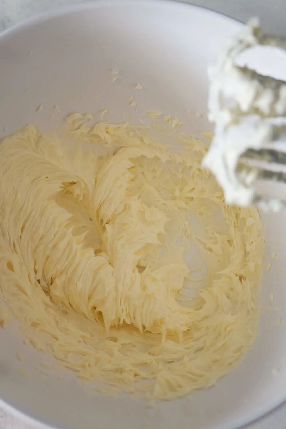 whipped butter and icing sugar in a mixing bowl