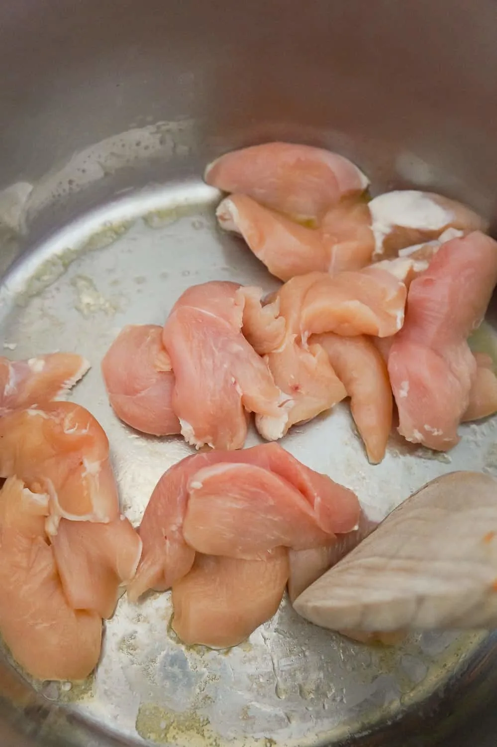 Raw chicken breast strips cooking in an Instant Pot