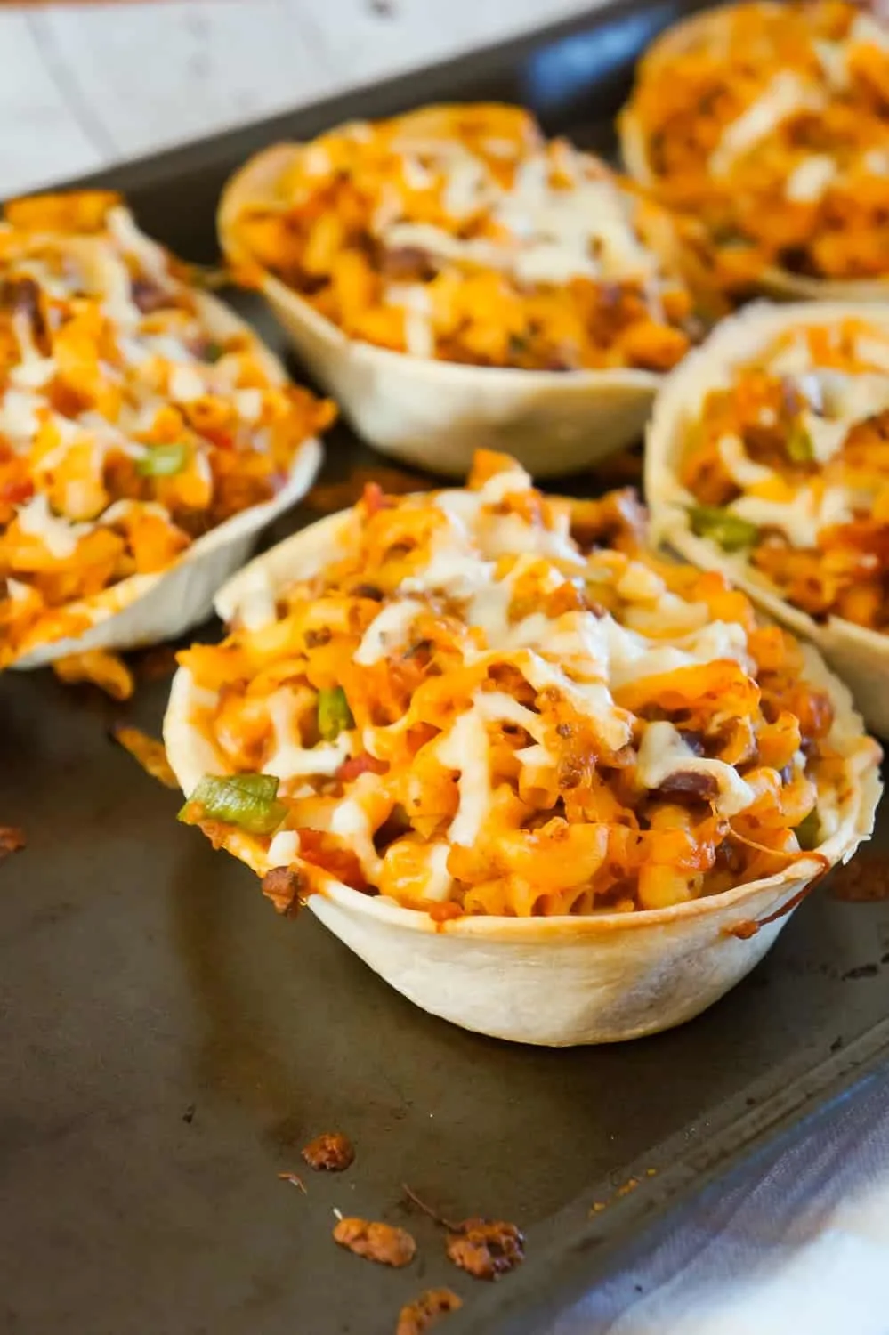 Taco Pasta is an easy ground beef dinner recipe that is fun and kid friendly. This cheesy macaroni tossed in salsa and taco sauce is baked in Old El Paso Tortilla Bowls.
