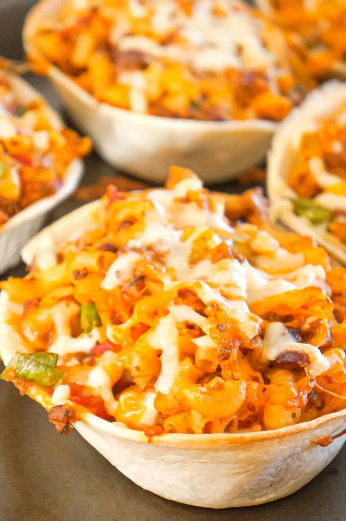 Taco Pasta is a delicious macaroni recipe loaded with ground beef, salsa, taco sauce and cheese all baked in soft shell taco bowls.
