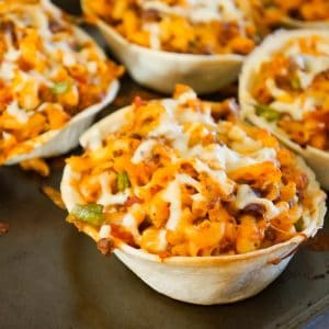 Taco Pasta is an easy ground beef dinner recipe that is fun and kid friendly. This cheesy macaroni tossed in salsa and taco sauce is baked in Old El Paso Tortilla Bowls.