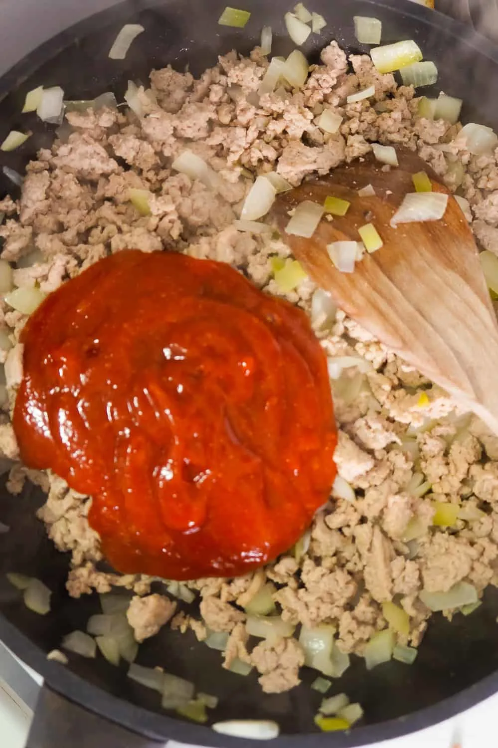 sloppy joe sauce on top of cooked ground turkey in a frying pan