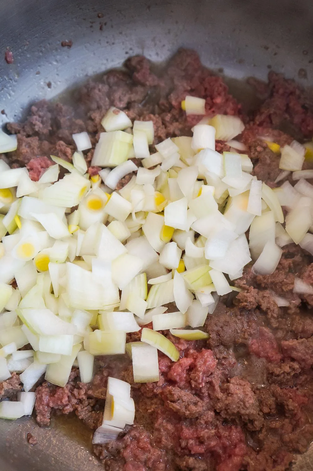 diced onions and ground beef cooking in large pot