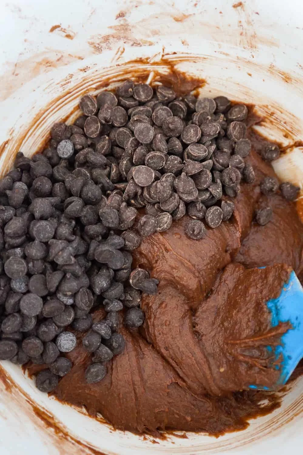 semi sweet chocolate chips and dark chocolate chips added to brownie batter in a mixing bowl