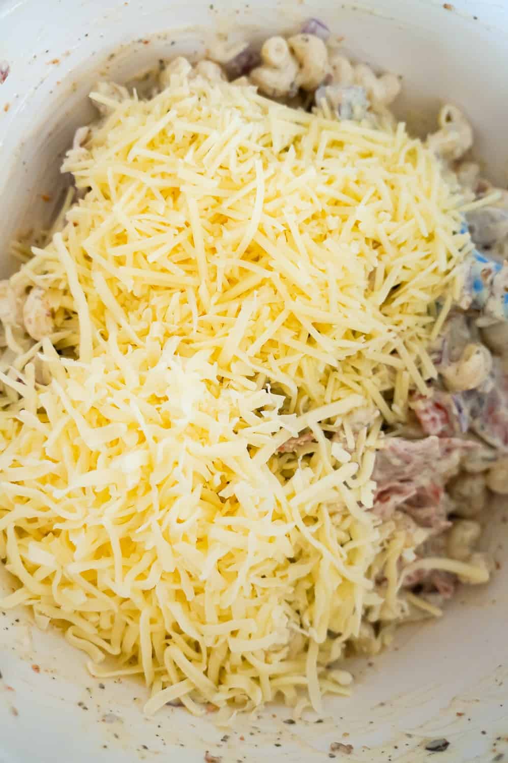 shredded Parmesan cheese and shredded mozzarella cheese on top of pasta salad