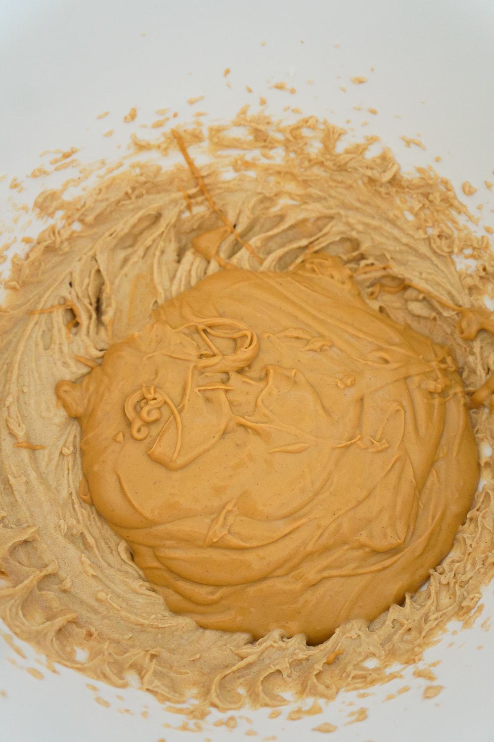 melted peanut butter chips added to peanut butter mixture in a mixing bowl