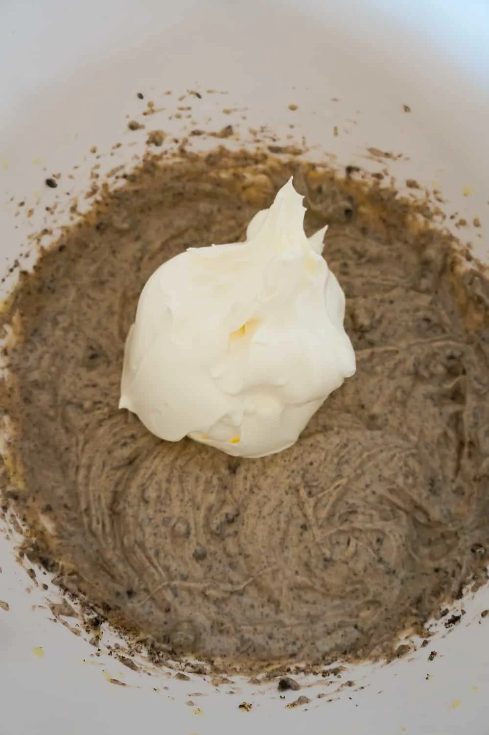 Cool Whip added to Oreo pudding mixture in a mixing bowl
