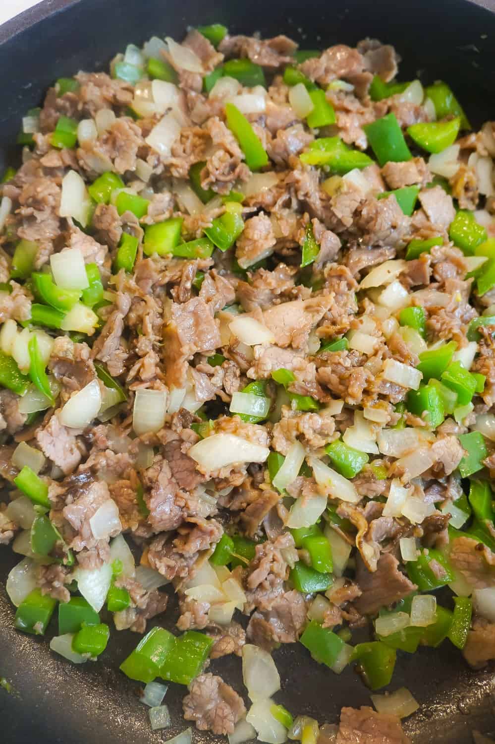 diced roast beef, diced green onions and diced onions in a frying pan
