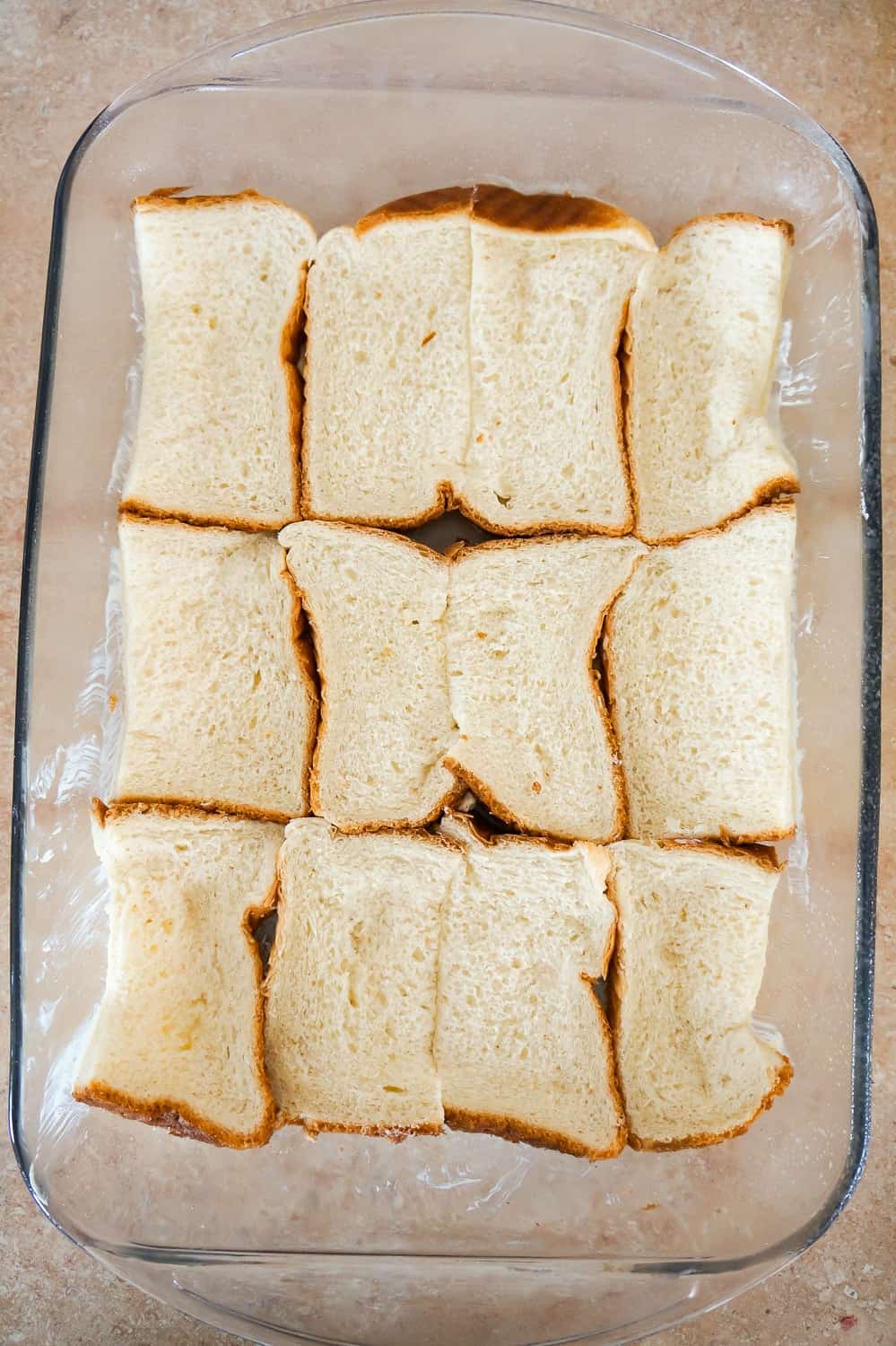 bread slices in the bottom of a baking dish