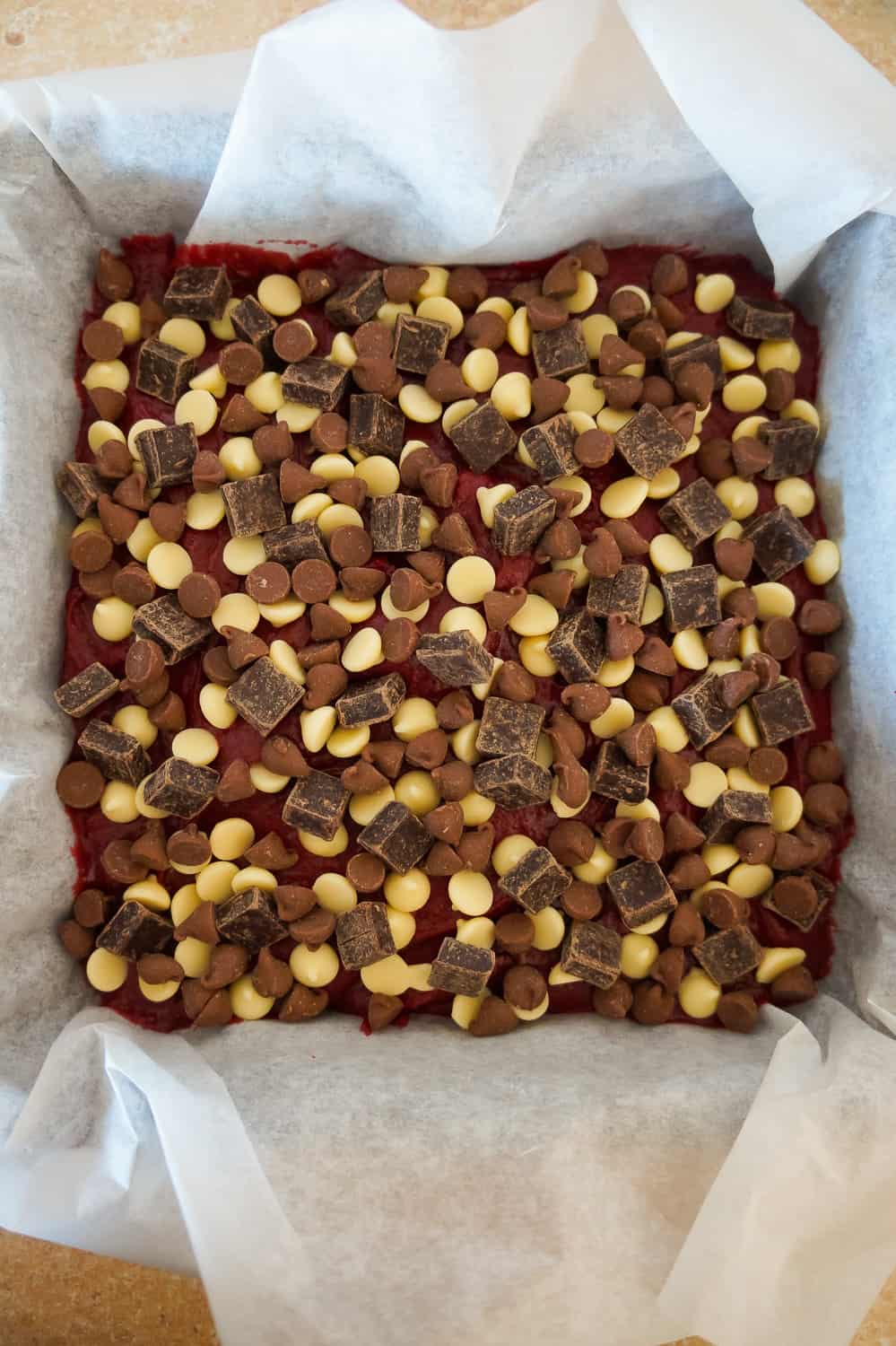 red velvet brownies with chocolate chips and and white chocolate chips on top before baking