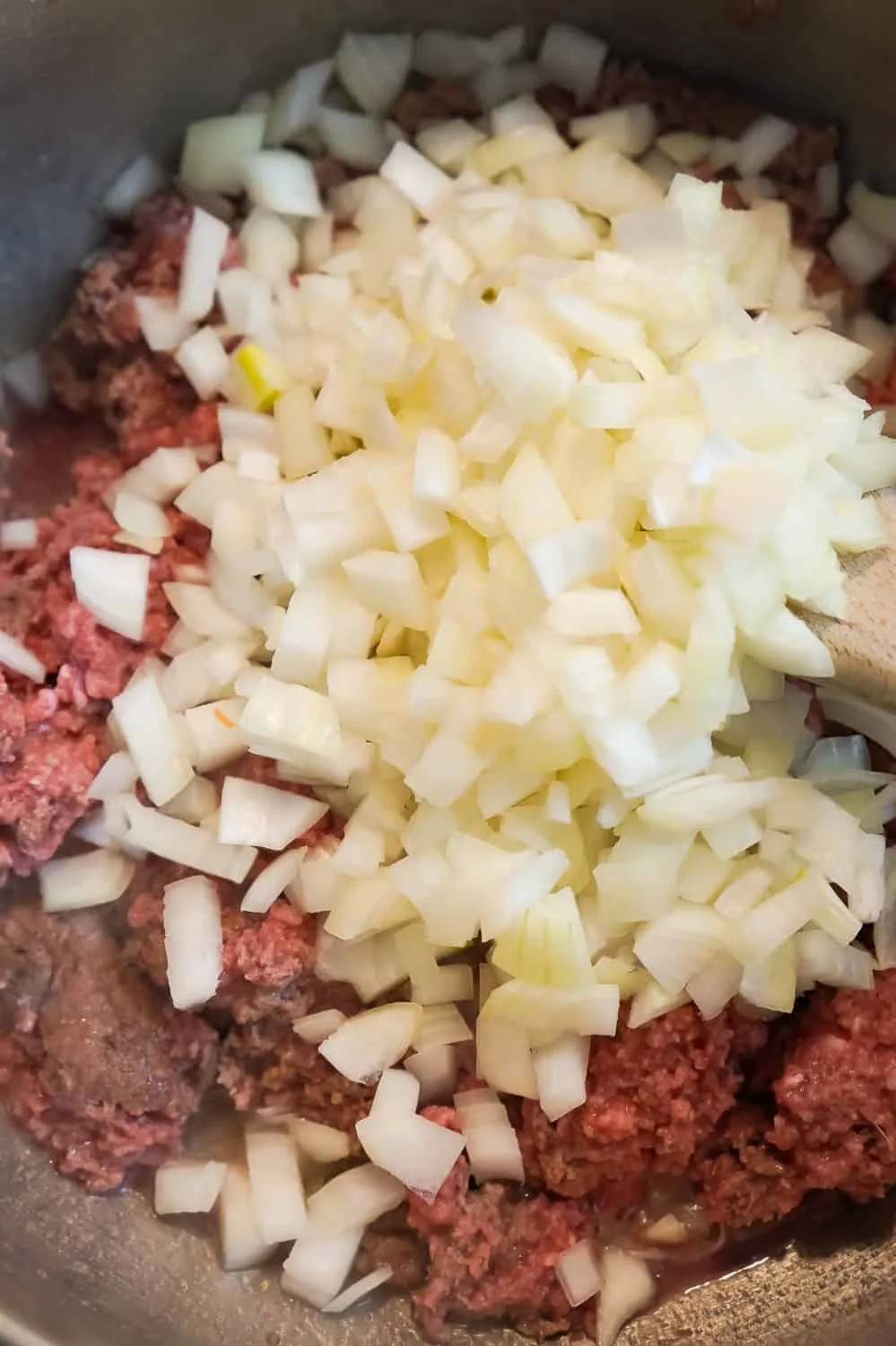 diced onions and ground beef cooking in a pan