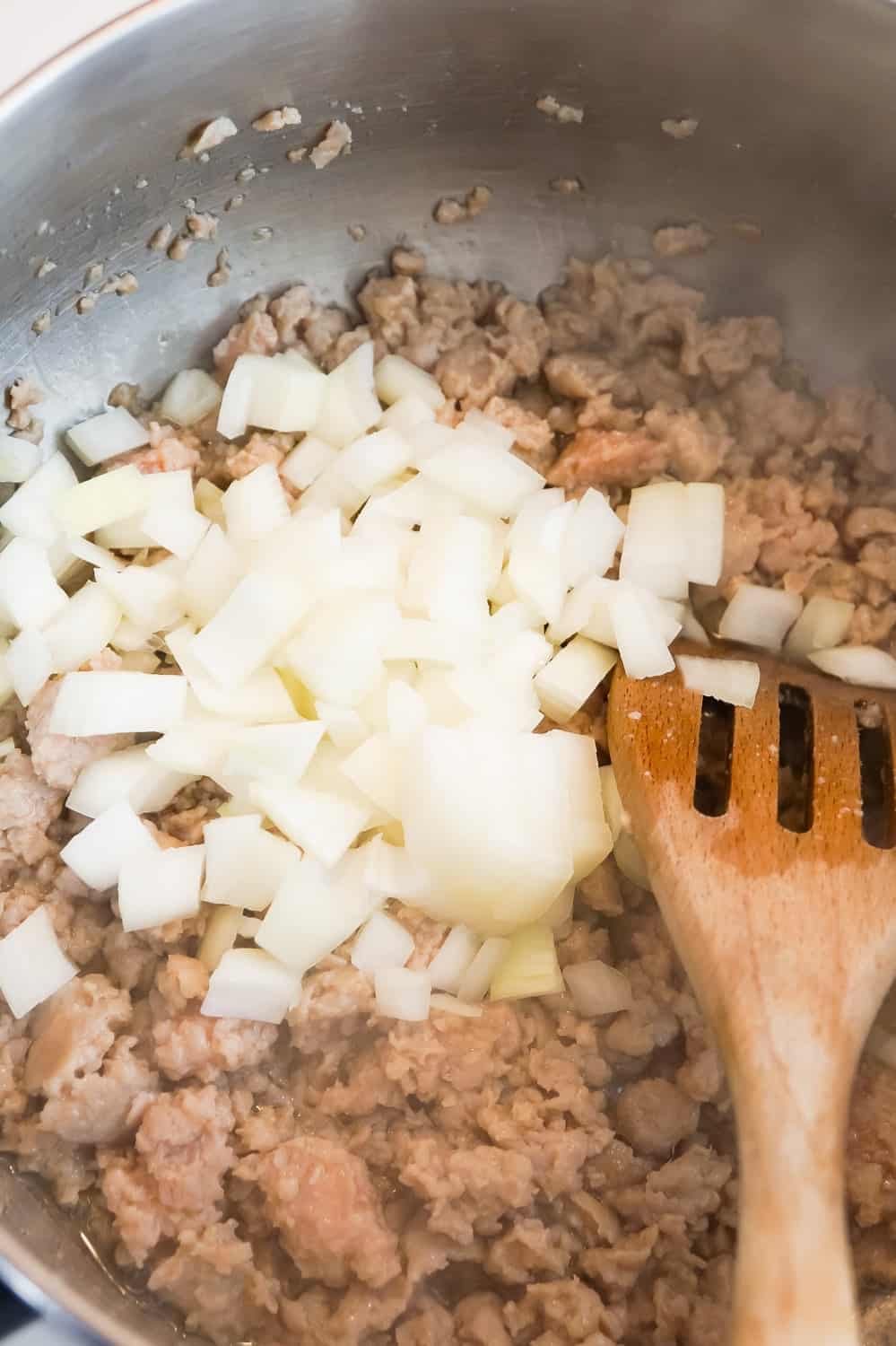 diced onions and sausage meat cooking in a pan