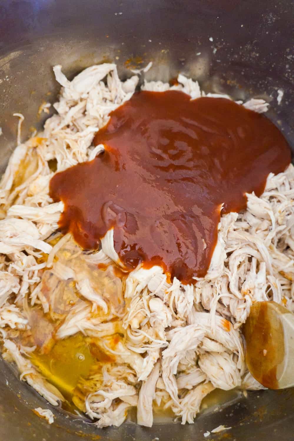 barbecue sauce and liquid honey added to shredded chicken in an Instant Pot