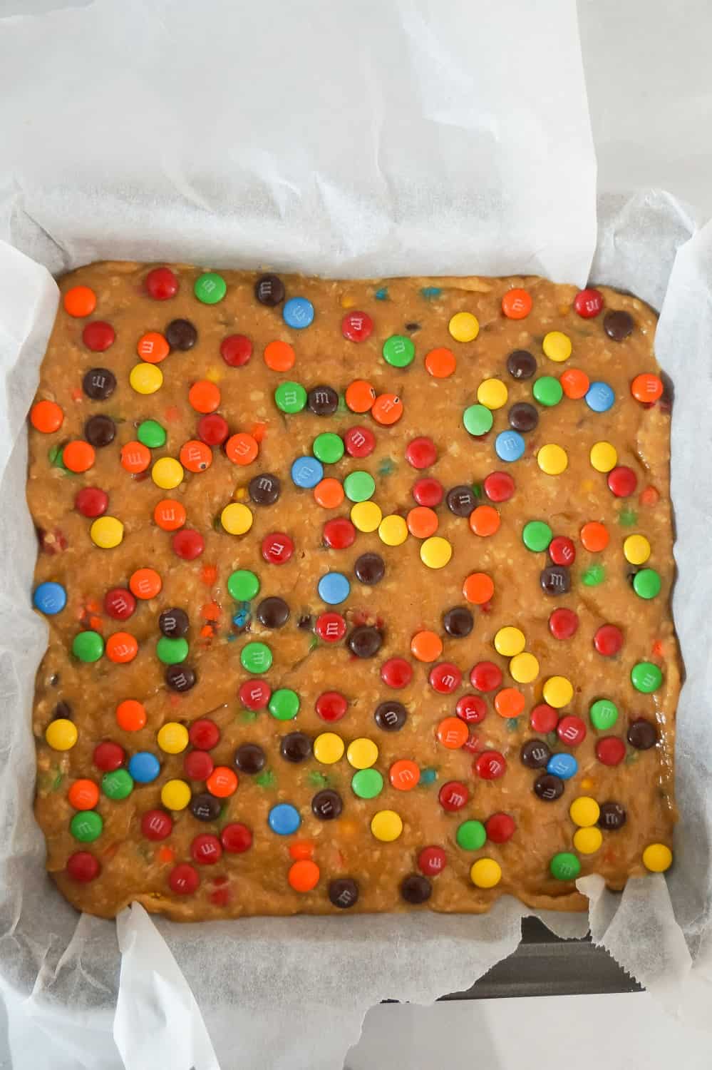 monster cookie dough fudge in a parchment lined baking pan
