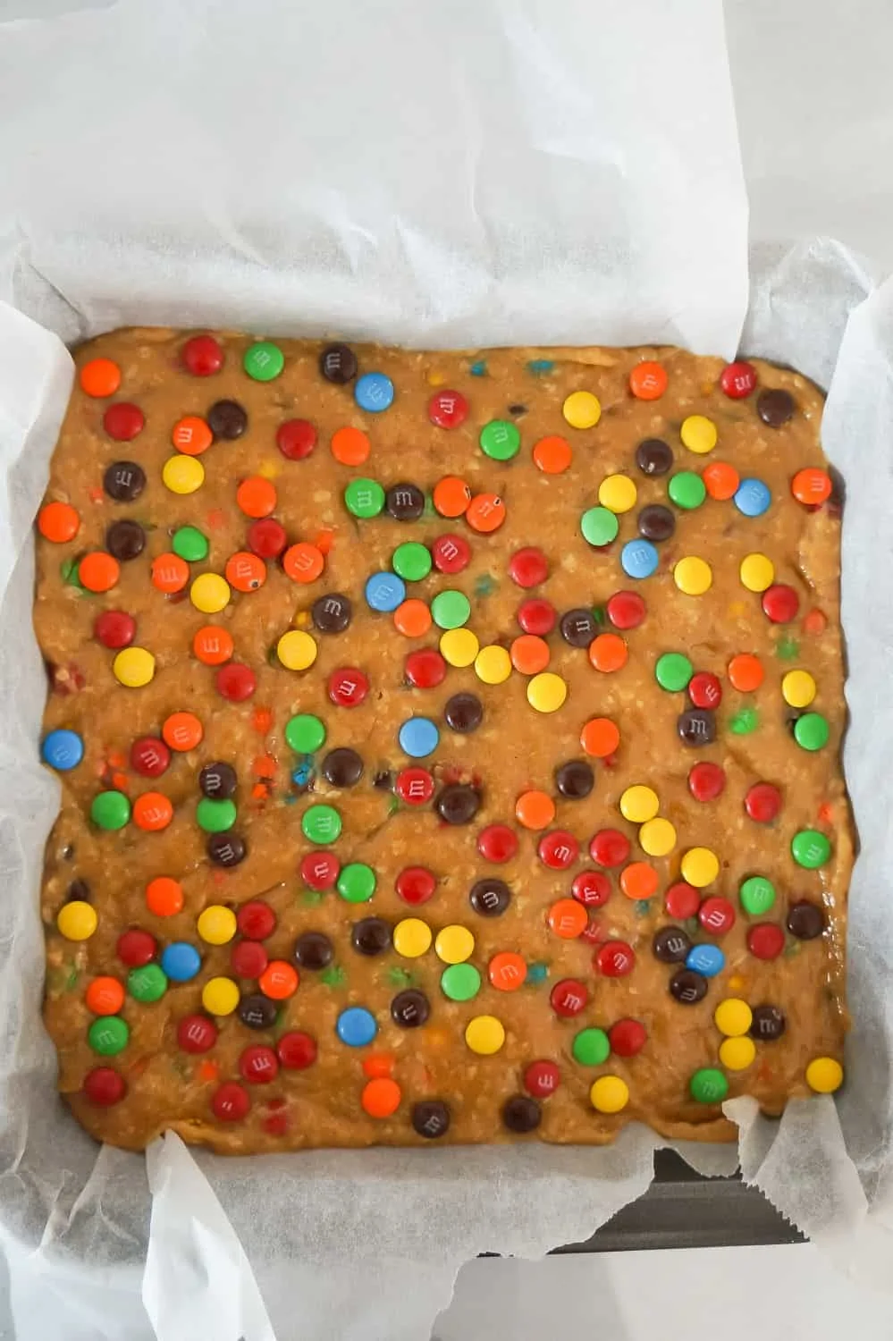 monster cookie dough fudge in a parchment lined baking pan